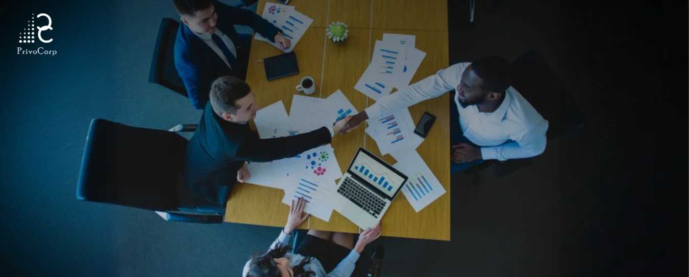 Group of people reading statistics and shaking hands over successful findings.